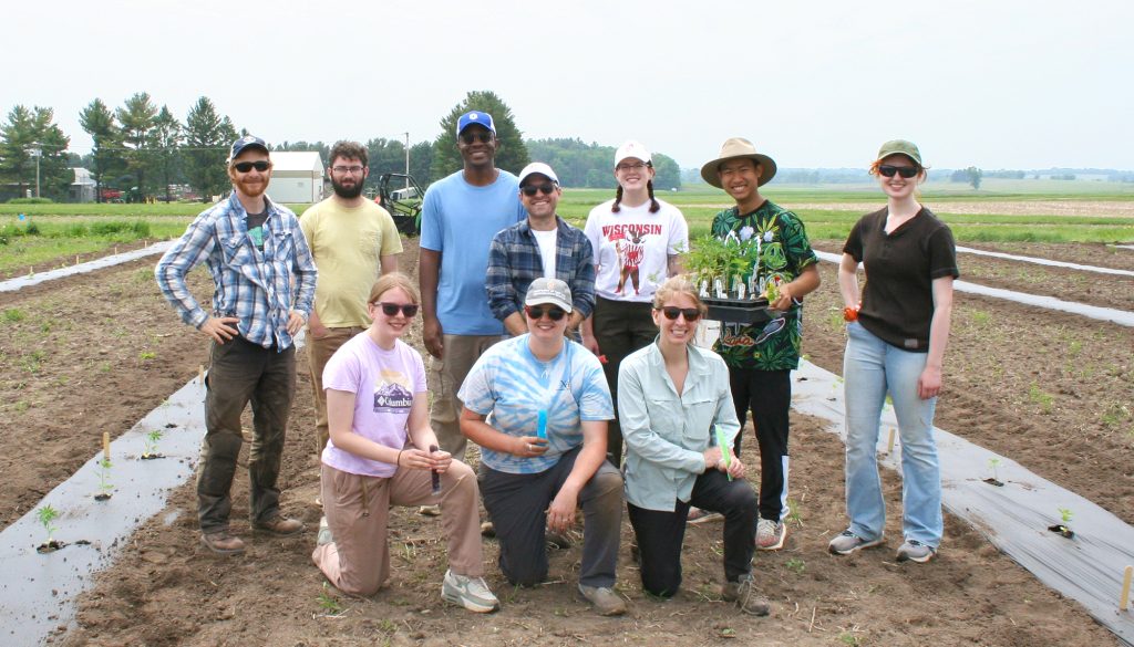 The Ellison Lab smiles for a photo in a field. 