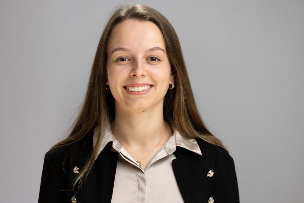 Taina smiles. She has long, brown hair.