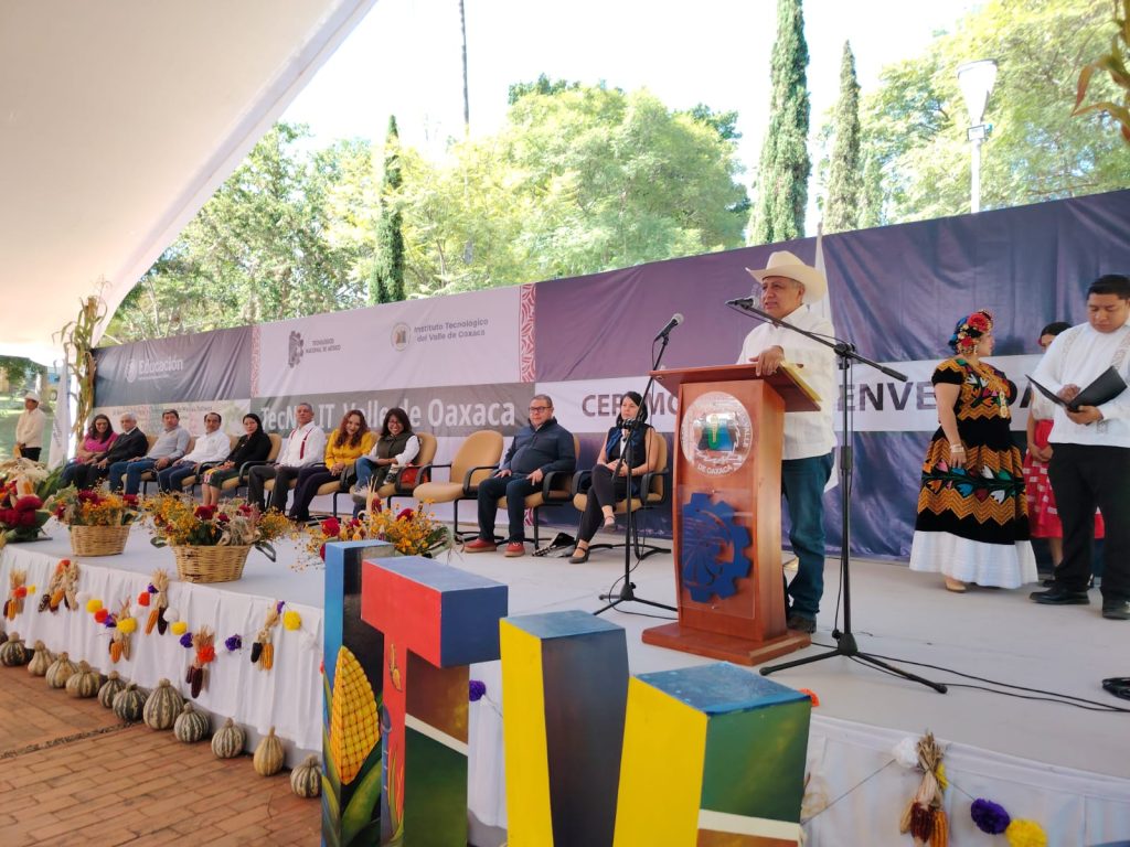 A person presents at a podium onstage.