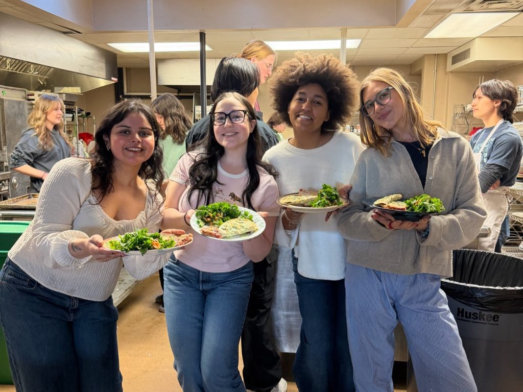 A group of students pose with plates of food.
