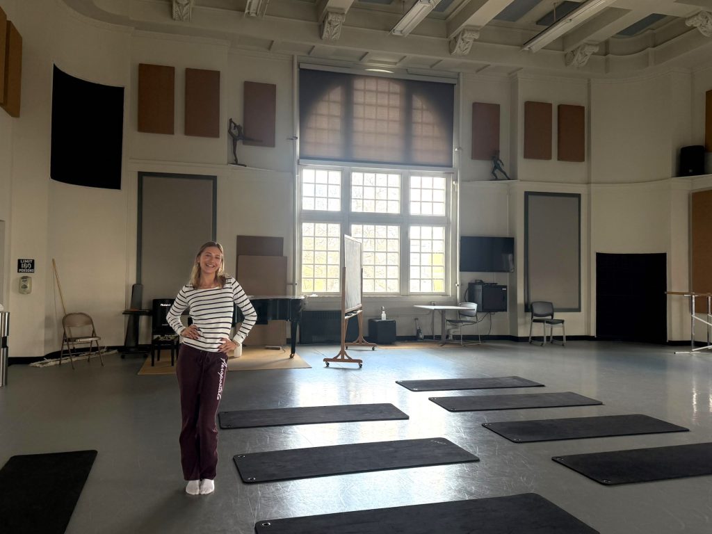 Hanf stands in a large room full of yoga mats.